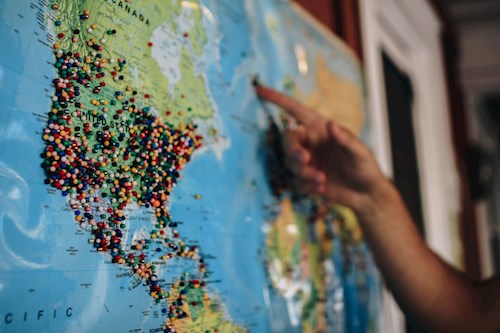 finger pointing to greenland on world map